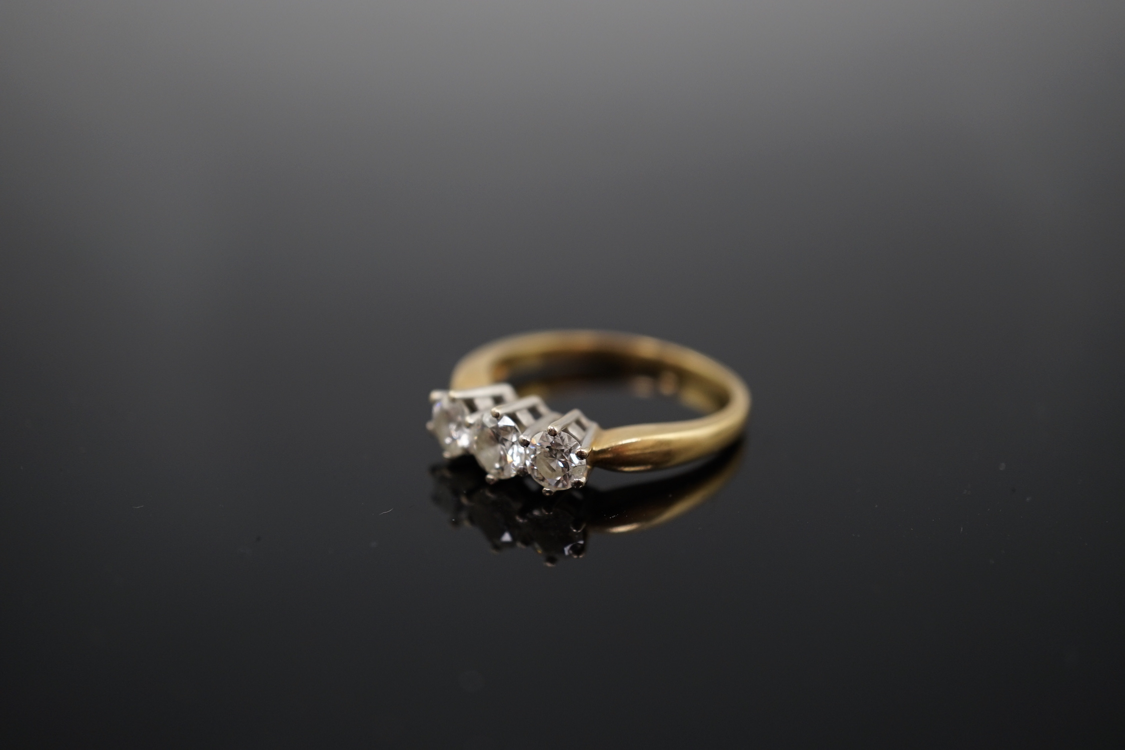 A modern 18ct gold and three stone diamond set ring